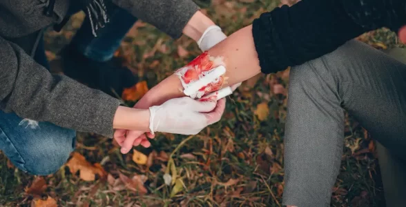 A person dresses a wound and stops the bleeding by using first aid learned at 4JH in Southampton.