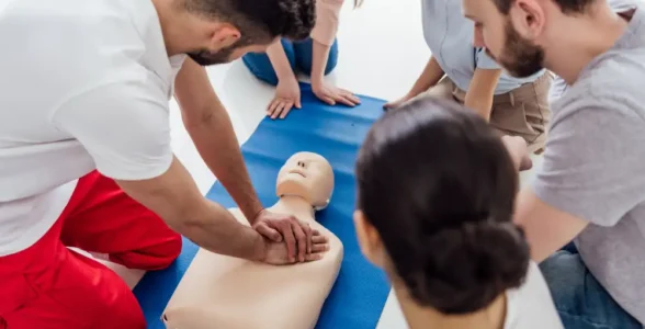 A First Aid at Work lesson is taking place with 4JH teaching people CPR on a dummy.